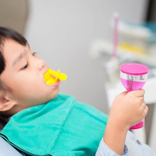 Child receiving fluoride treatment at a Brick dental office
