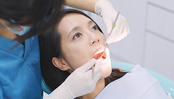 Dentist in Brick Township looking in patient’s mouth for oral cancer