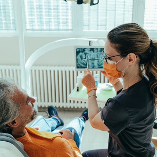 a dentist explaining All-On-4 to a patient in Brick Township