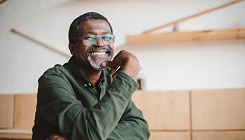 a person smiling with their hand on their chin