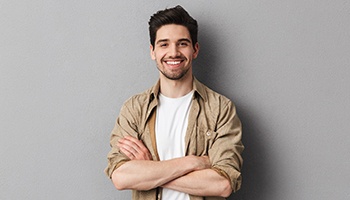 a smiling person with their arms crossed