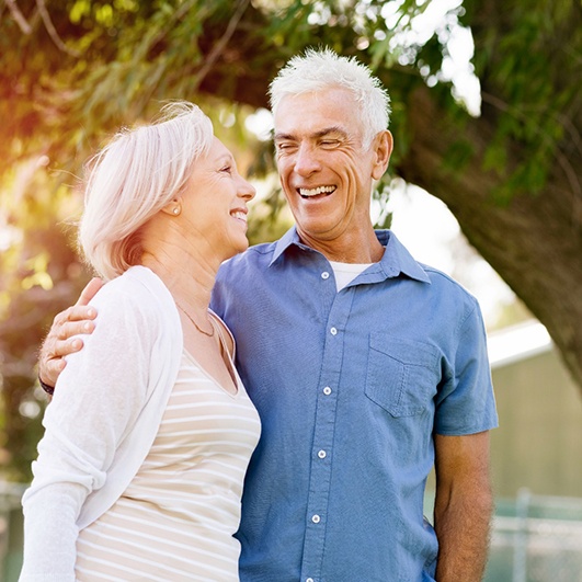 Older couple smiling after visiting a dentist in Brick Township