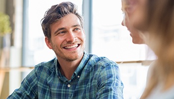 Man smiling with friends at restaurant