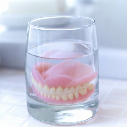 Dentures soaking in a solution