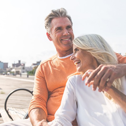 Older couple with dentures in Brock Township smiling outside