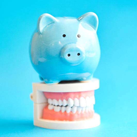 piggy bank sitting on top of teeth