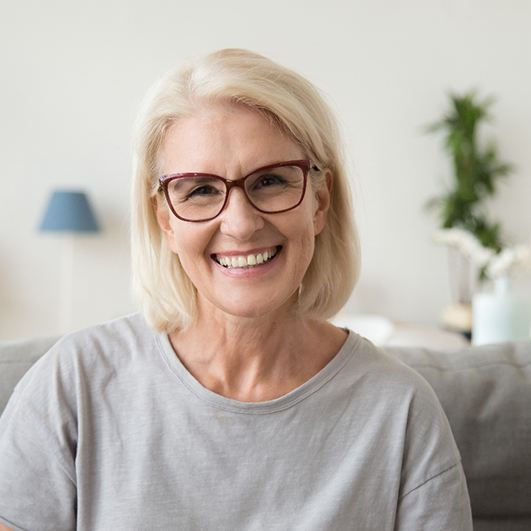 Woman with dental implants in Brick Township smiling at home