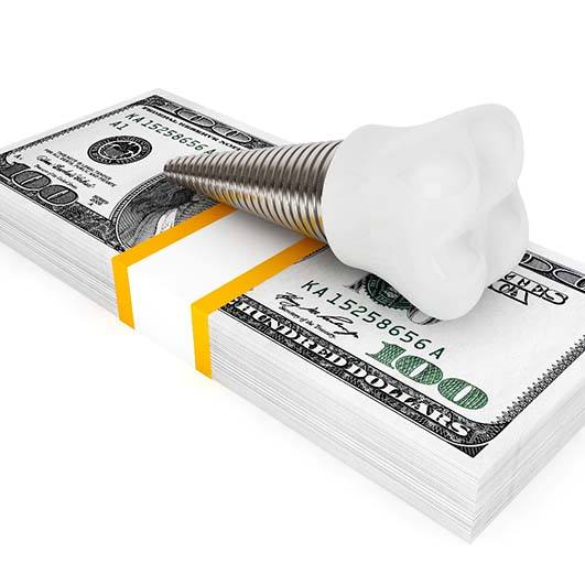 Implant on money representing the cost of dental implants in Brick Township