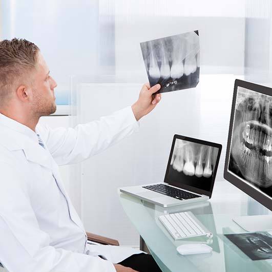 Brick township implant dentist looking at X-rays