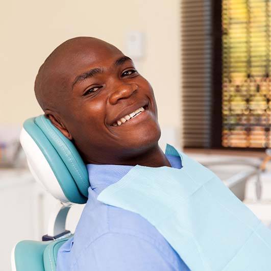 Man smiles while visiting his Brick Township implant dentist during appointment