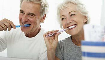 Older couple with dental implants in Brick Township brushing their teeth