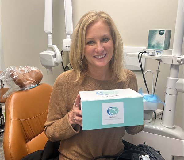 Woman in dental chair smiling at dentist