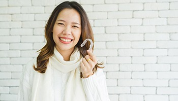 Woman holding Invisalign aligner