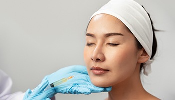 a person receiving a derma filler injection in their lip