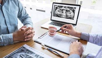 a dentist explaining the cost of root canal therapy