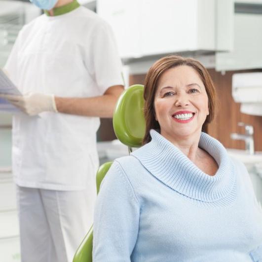 a patient smiling after undergoing full mouth reconstruction