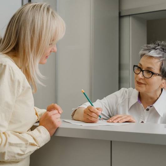 a patient talking to front desk about cost of treatment