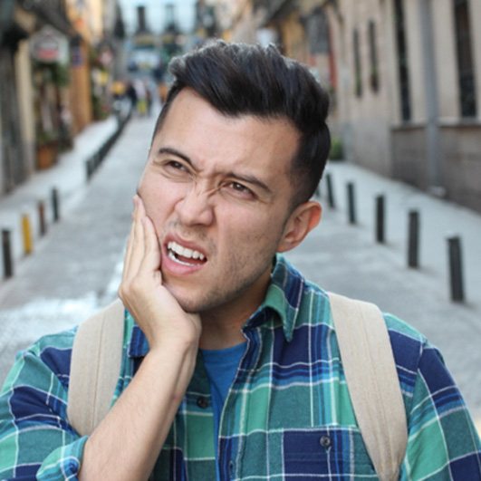 Man rubbing jaw due to pain from wisdom teeth in Barnegat, NJ