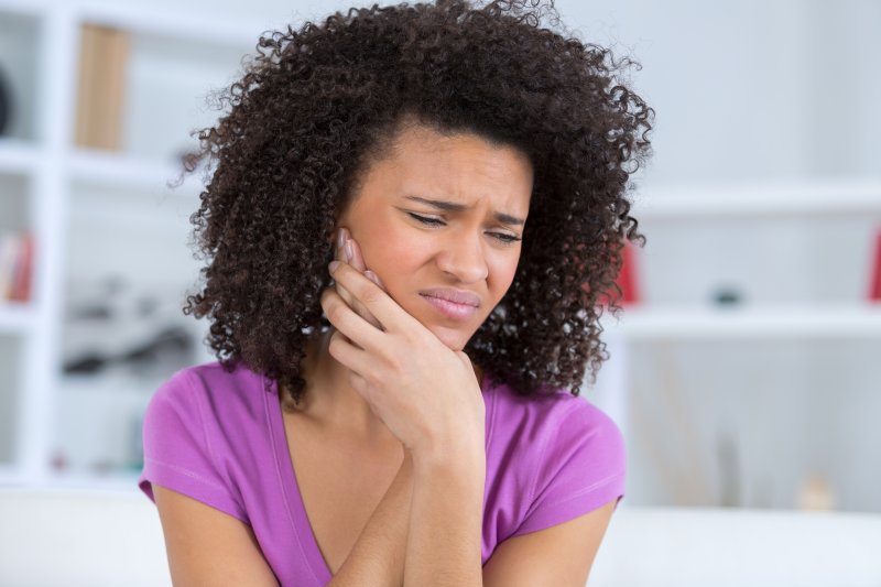 Woman holding her jaw because of a wisdom tooth