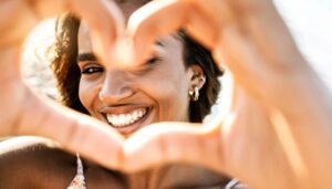 Smiling woman making heart shape with her fingers 